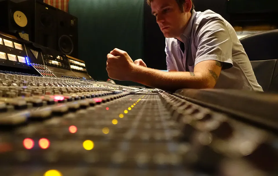 Jay Maas leaning over a mixing console