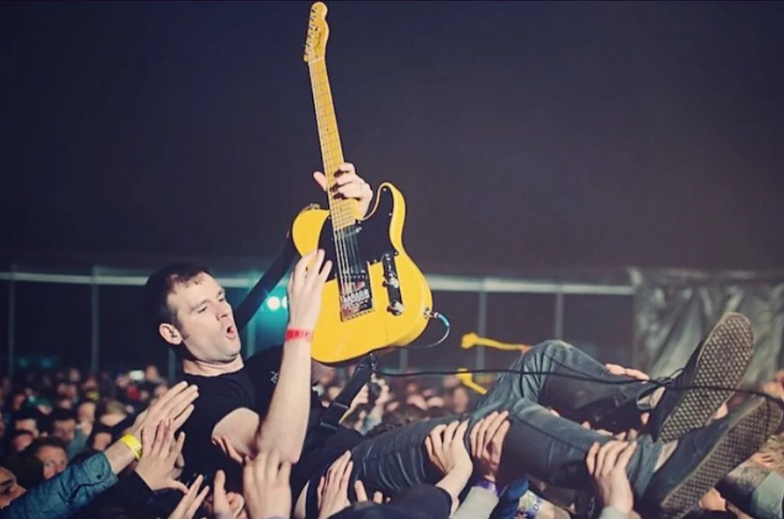 Jay Maas stage diving with his guitar